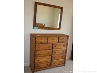 Front view of dresser with ten large drawers and five smaller top drawers, solid wood in natural finish.