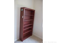 Adjustable wooden bookcase with multiple shelves and reddish-brown finish.