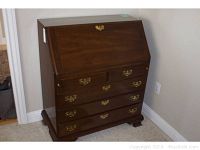 Closed solid wood library desk with brass hardware and decorative bracket feet