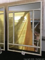 Front view of one medium-sized rectangular mirror with white bamboo-style wooden frame and visible spindle details in bamboo sections, reflecting yellow curtain.