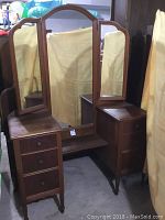 Front view of the antique wooden vanity with mirrored top and six drawers showing overall condition and structure