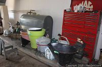 Wide view showing collection of flower pots, galvanized pail, watering can, and other garden items