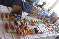 Wide view of assorted PEZ dispensers, vintage toys, and animal figures on a tabletop.