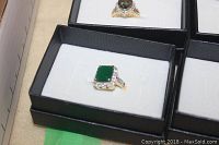 Photo of costume ring with large square green stone and clear accents in black box