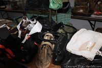 Mixed purses and carry bags piled on a wooden table