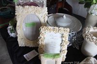 Close-up of two ornate ivory picture frames with floral designs, note of condition with some wear and stains.