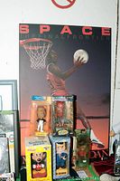 Overview photo showing five bobble heads standing in front of a Michael Jordan poster, including a basketball player, Spider-Man, Mr. Business, Tiger Woods, and Mickey Mouse in original packaging.