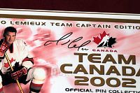 Close-up of signed Mario Lemieux Team Captain Edition Team Canada 2002 official pin collection signage with hug logo and signature.