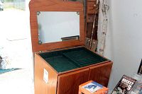 Open jewelry tower showing top compartment with a mirror and green felt lined sectioned drawer.