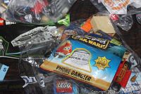 Photo showing Lego Star Wars themed Angry Birds phone dangle in original packaging alongside assorted Lego pieces.