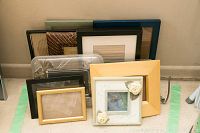 Group of 10 assorted picture frames in various sizes and styles, arranged against a wall.