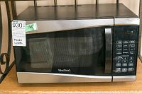 West Bend microwave model EM925AJWP1 showing front with digital keypad and door handle.