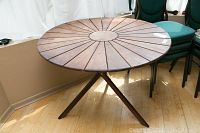 Photo of entire round solid wood table with tripod base showing radial slat design on tabletop and overall condition.