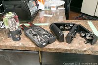 Photo of two separate wine opener sets displayed open on a kitchen counter, showing metal and plastic components inside each case for opening and preserving wine bottles.