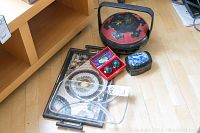 Overall lot displayed on wood floor including glass platter, Asian tray, lacquered bowl with handle, small blue porcelain box and green health balls in red box.