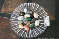 Clear Mikasa glass bowl filled with a variety of decorative stone and gem eggs, 16 inch diameter bowl shown from overhead on a table surface.