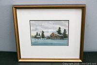 Framed watercolour painting of a rustic farm scene with two barns and pine trees under a cloudy sky.