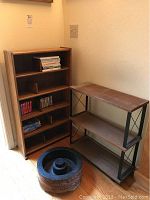 Tall wooden 5-tier media shelf, smaller 2-tier media shelf with black metal frame, and black cast iron decorative stand on floor.