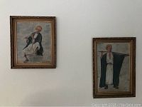 Two framed paintings of figures in traditional attire hung on wall.