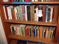 Books arranged on two wooden shelves, showing a range of titles mainly in historical, political, and fiction categories.