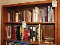 Two stacked shelves filled with a variety of books regarding world geography, history, and social subjects. Titles feature different sizes, colors, and bindings.
