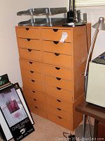 Stack of six wooden storage drawer cubes each with three drawers, natural wood finish, finger pull cutouts on drawers