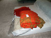 Four woven blankets folded and placed on couch, showing colors and packaging